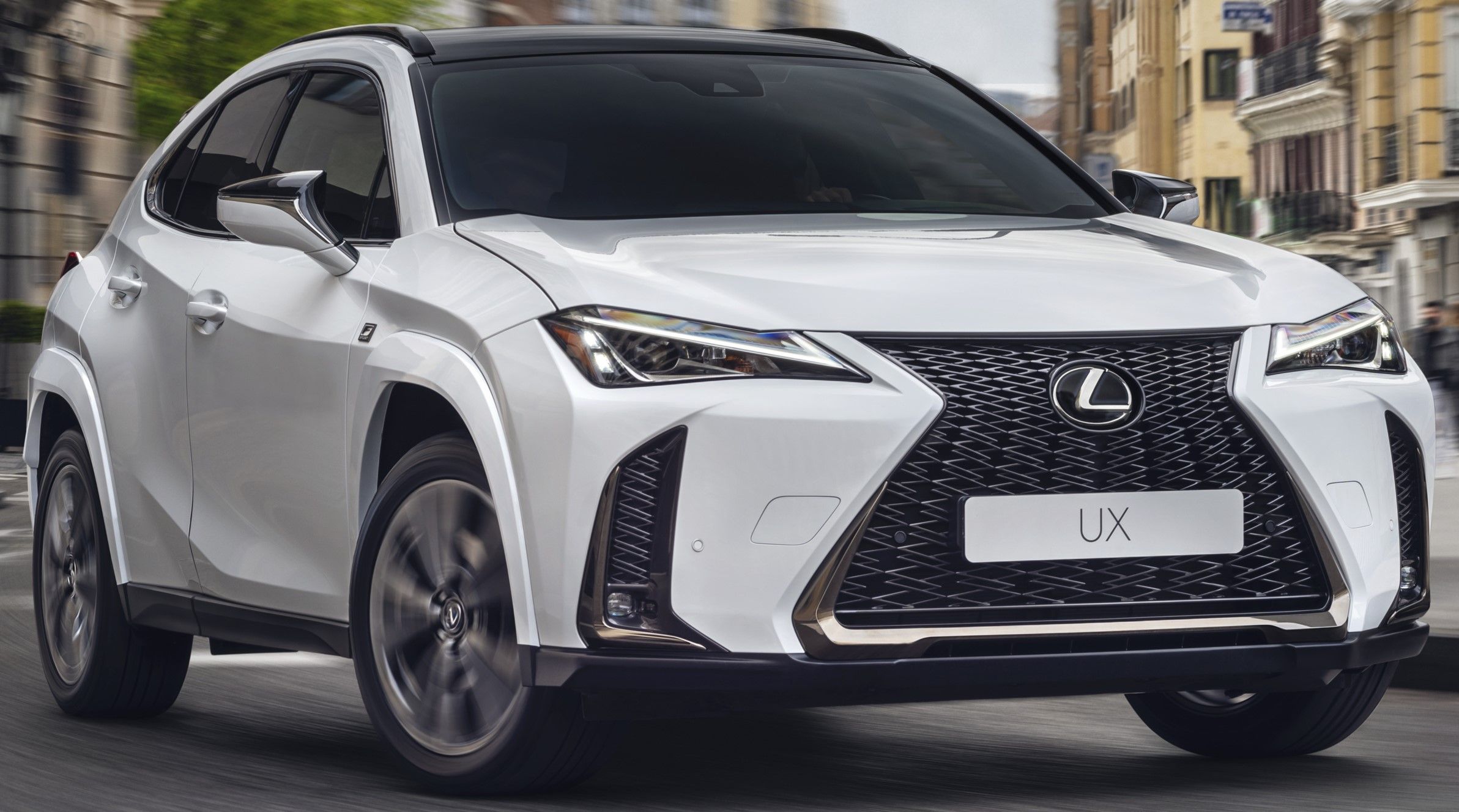 White 2023 Lexus UX 250h F Sport driven on the road