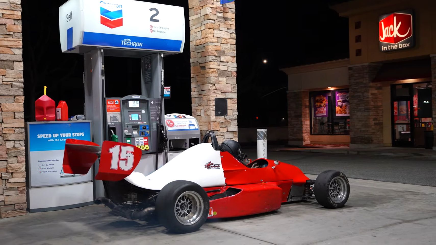 Uma Fórmula Mazda vermelha de 1984 em um posto de gasolina