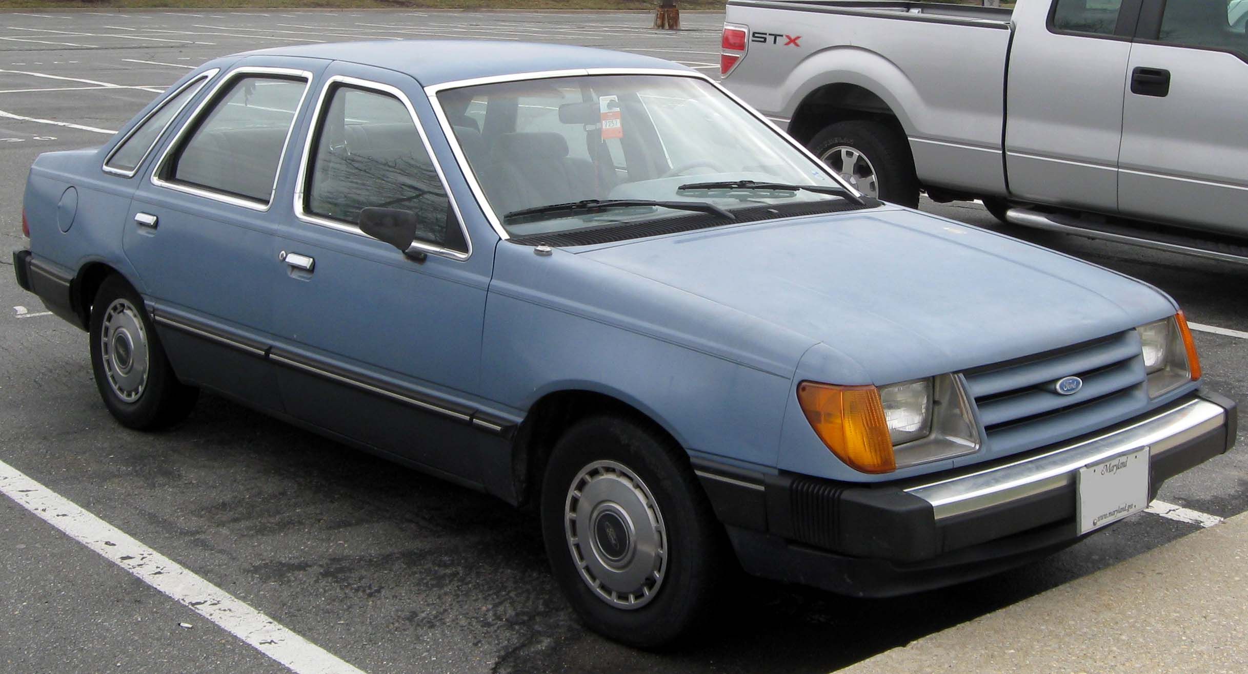 Blue 1984 Ford Tempo in the parking lot