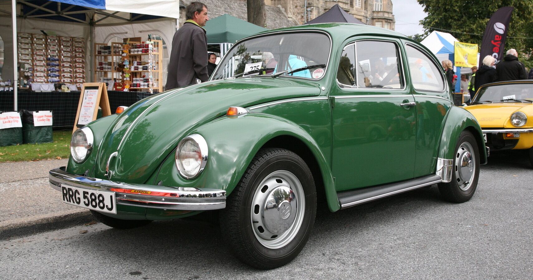 A green 1971 Volkswagen Beetle parked outside