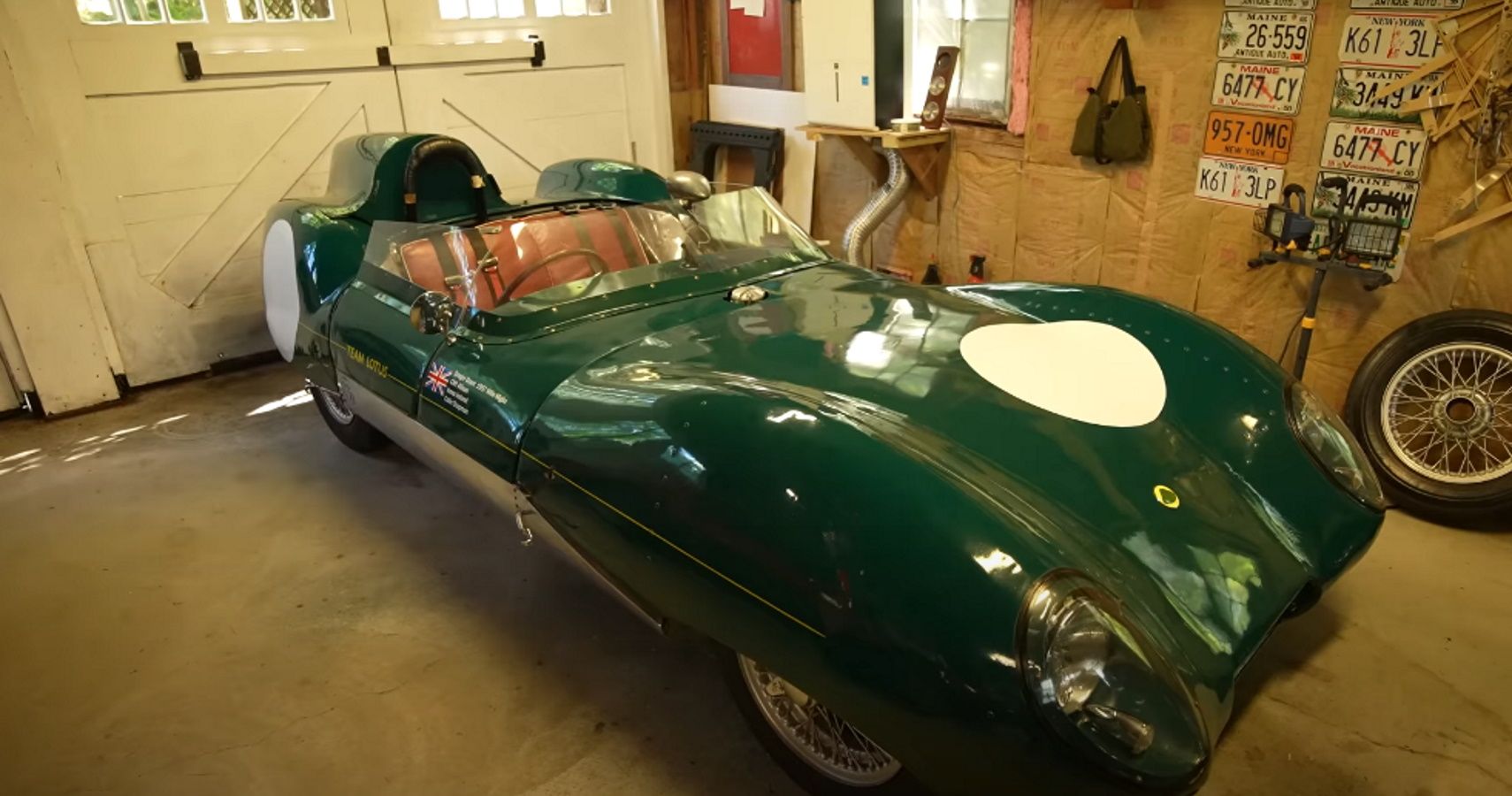 A green Lotus Eleven race car in a garage