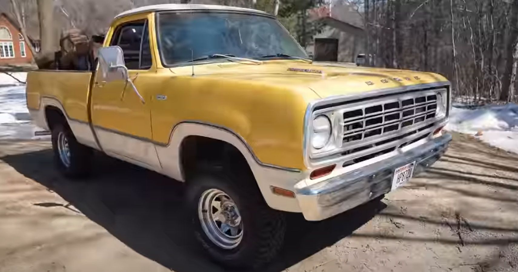 A yellow and white 1975 Dodge D100 Power Wagon in a driveway