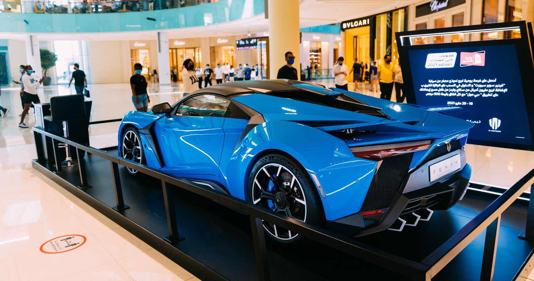 Blue W Motors Fenyr SuperSport inside a shopping mall in Dubai Rear third quarter close up view