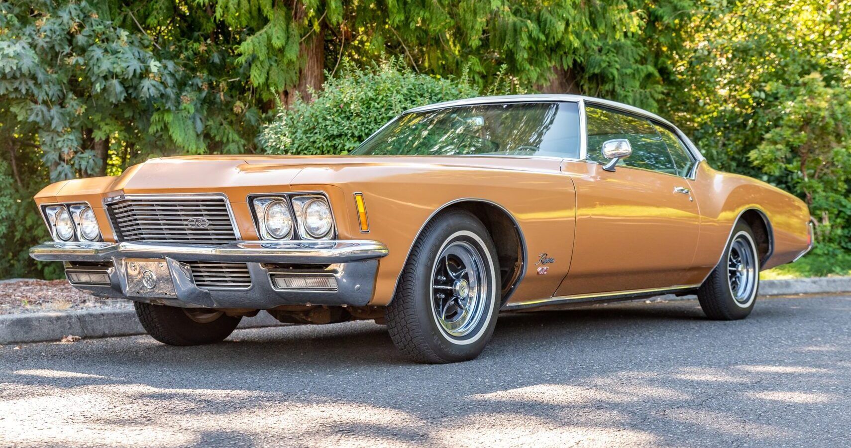 Um Buick Riviera GS dourado 1971 estacionado