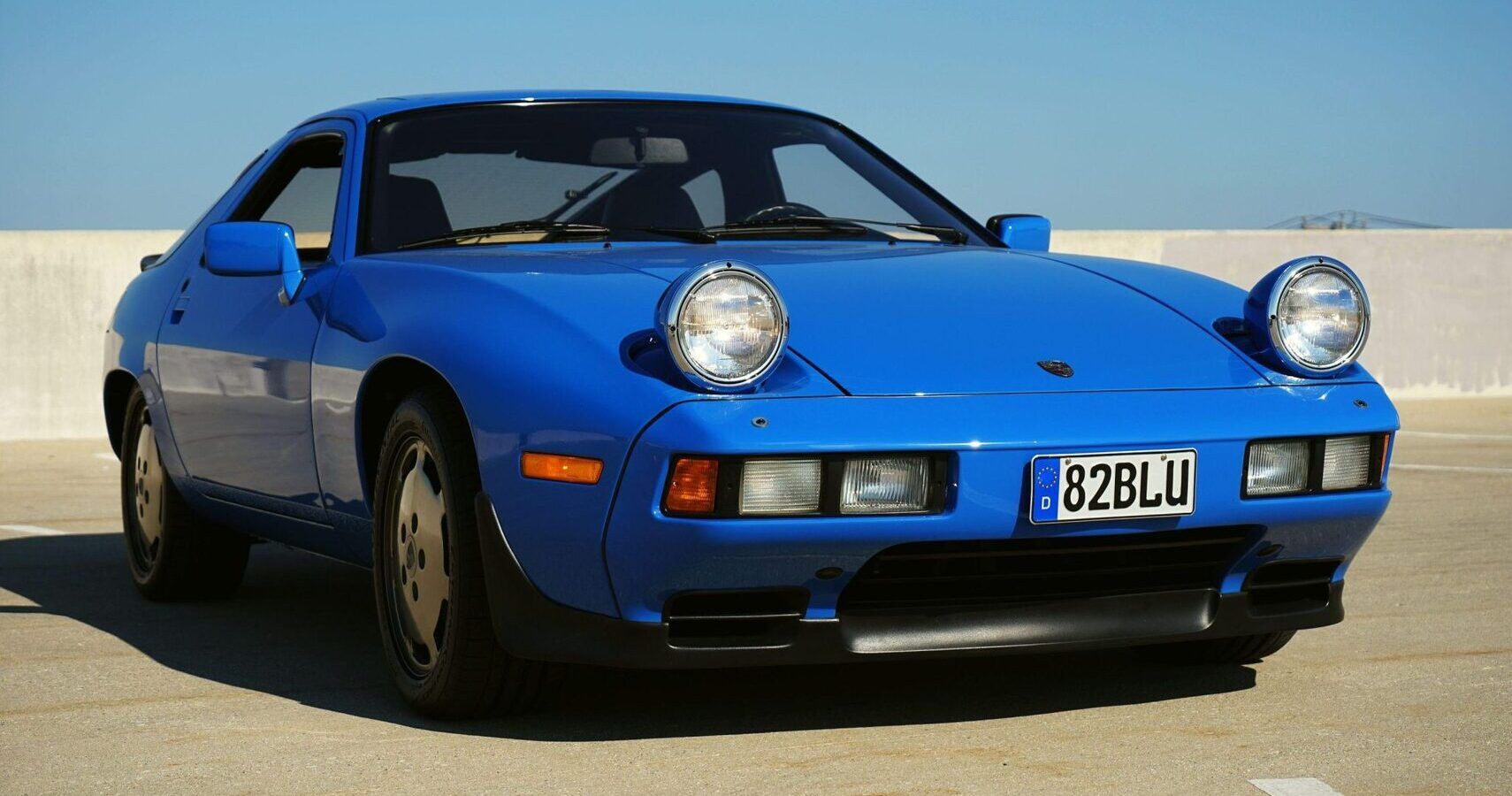 Blue Porsche 928 sports car parked