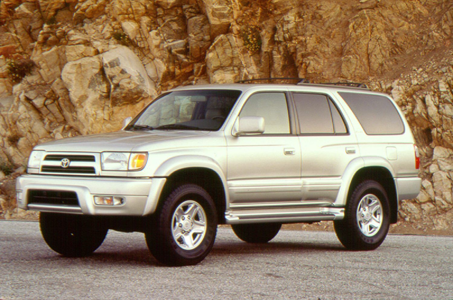 Grey 1998 4Runner parked in front of a rock wall