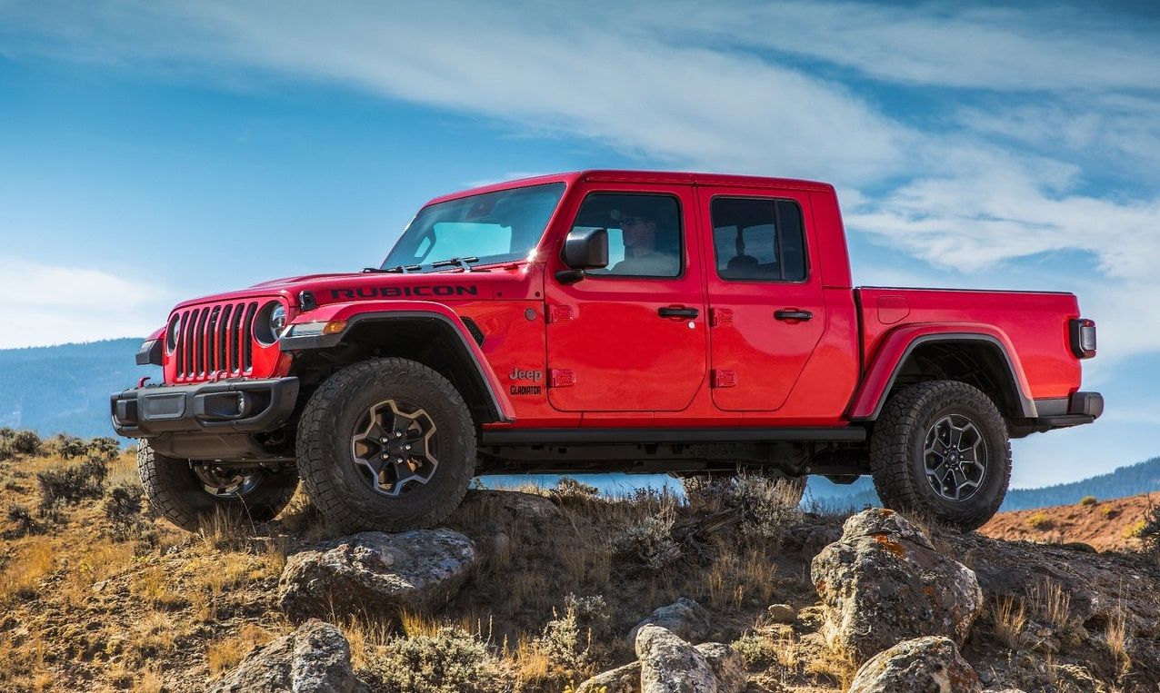 Um ângulo lateral de um Jeep Gladiator vermelho de 4 portas. 