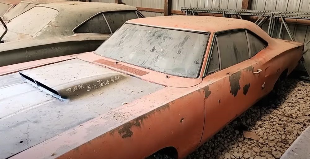 A red 1969.5 Dodge A12 Super Bee in a barn with other Mopar muscle cars