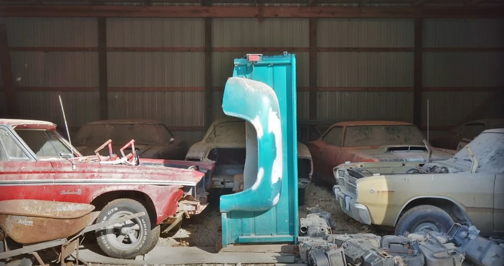 The entrance to a barn with a 1965 Plymouth Belvedere II (left) and a 1968 Dodge Dart