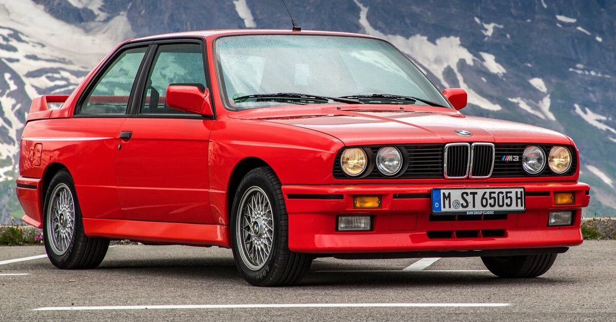 A red 1987 BMW M3 parked