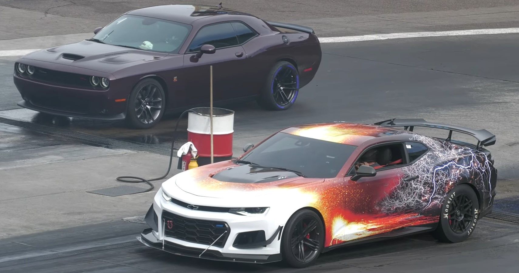 A wrapped Chevrolet Camaro ZL1 racing a purple Dodge Challenger Scat Pack