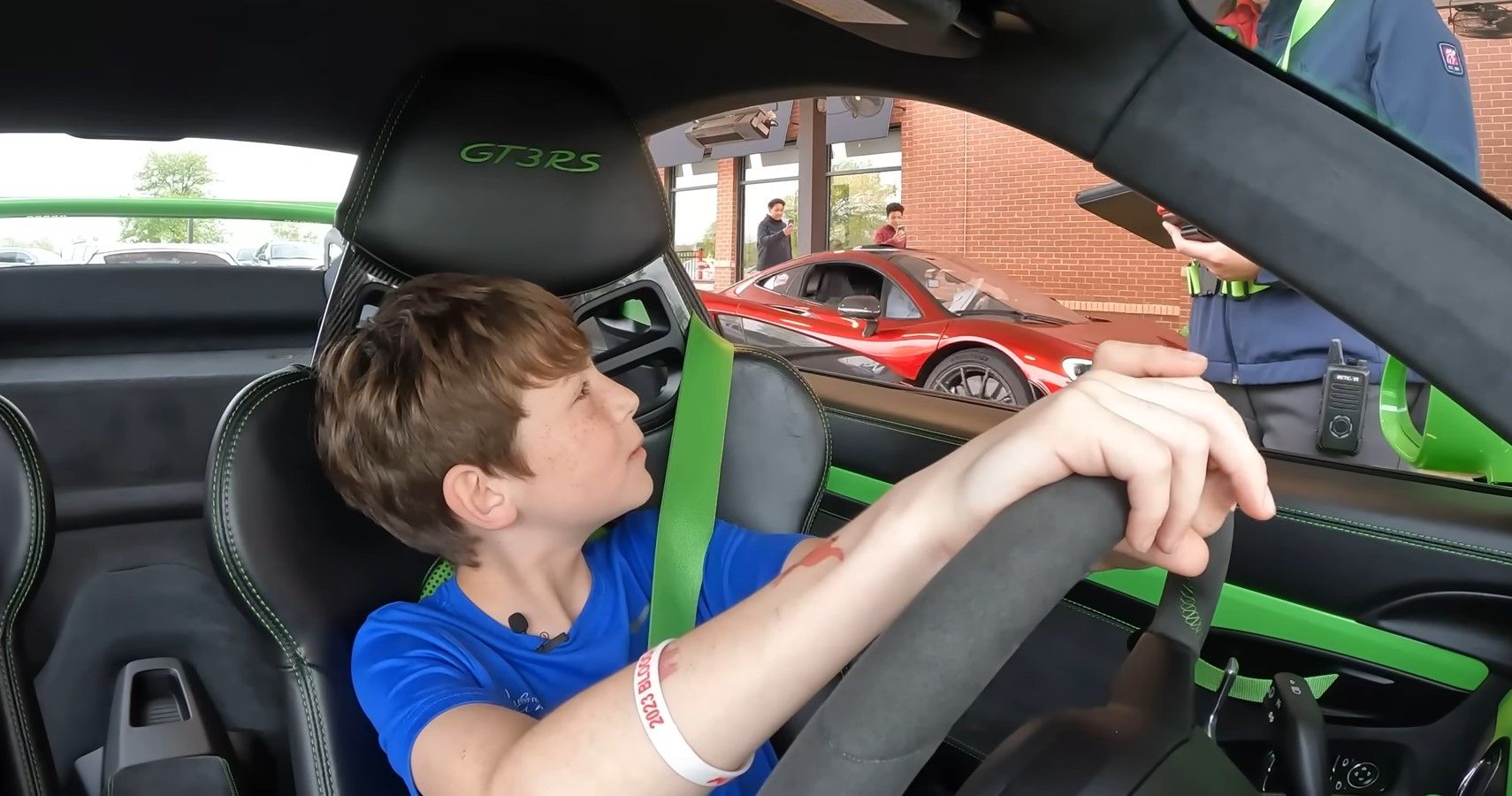 Um menino de 10 anos faz um pedido em um drive-thru em um Porsche 911 GT3 RS