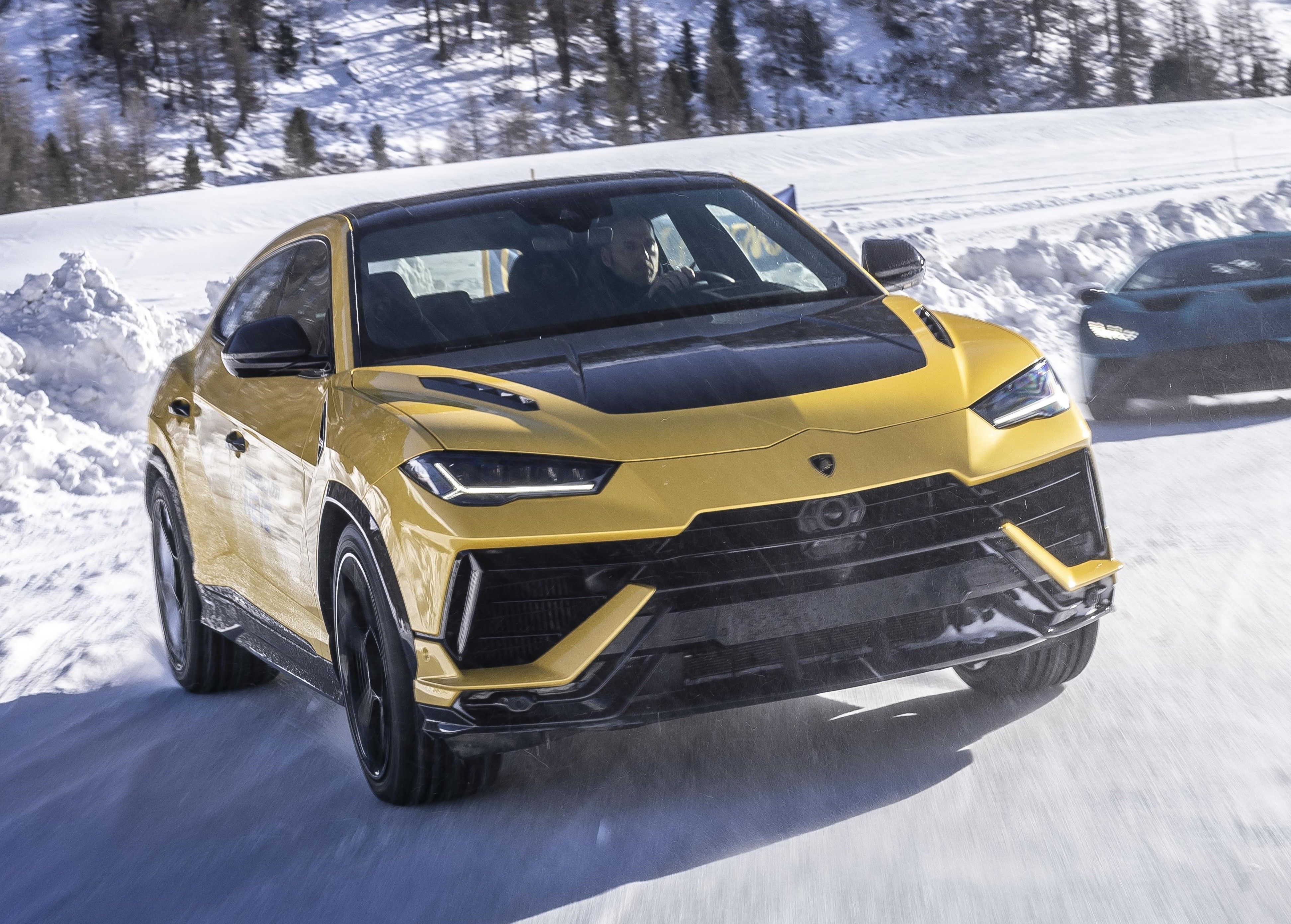 Yellow Lamborghini Urus S driven on a snow-covered road