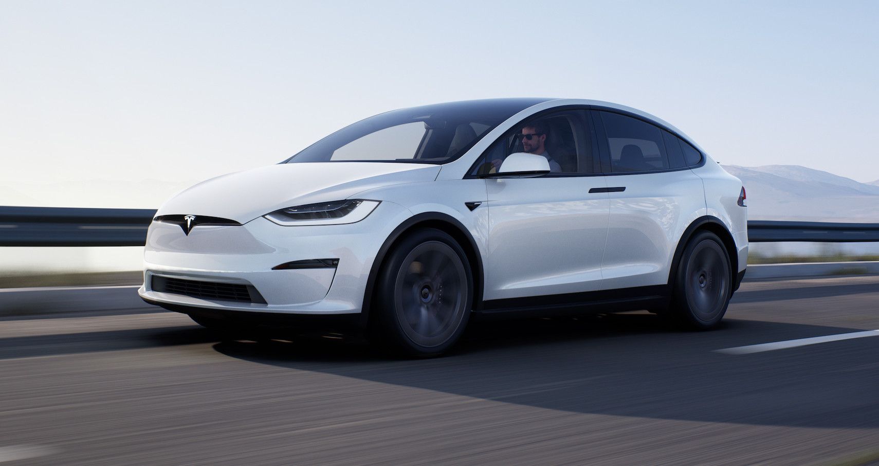 Tesla Model X branco conduzido na estrada