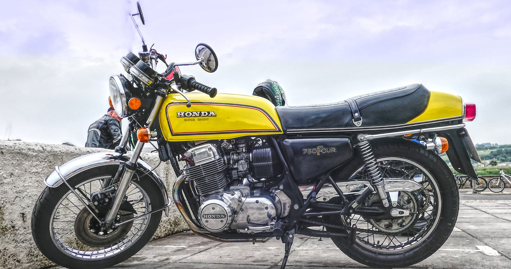 Yellow Honda CB750 side on in a parking lot