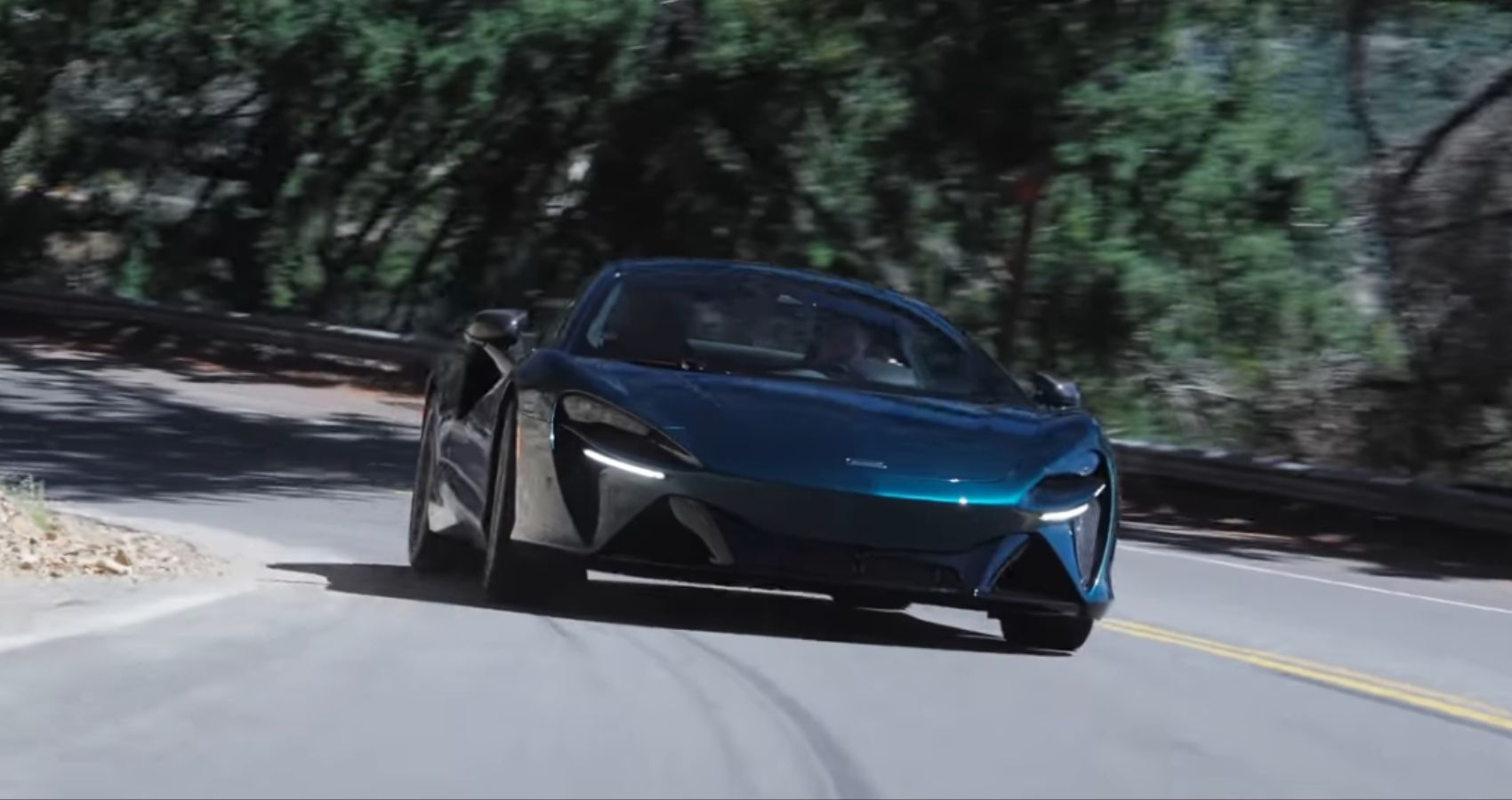 McLaren Artura Throttle House Front Quarter View Dirigindo em estrada sinuosa