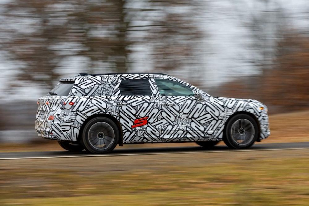 Side view of a camouflaged 2024 Acura ZDX Type S in motion