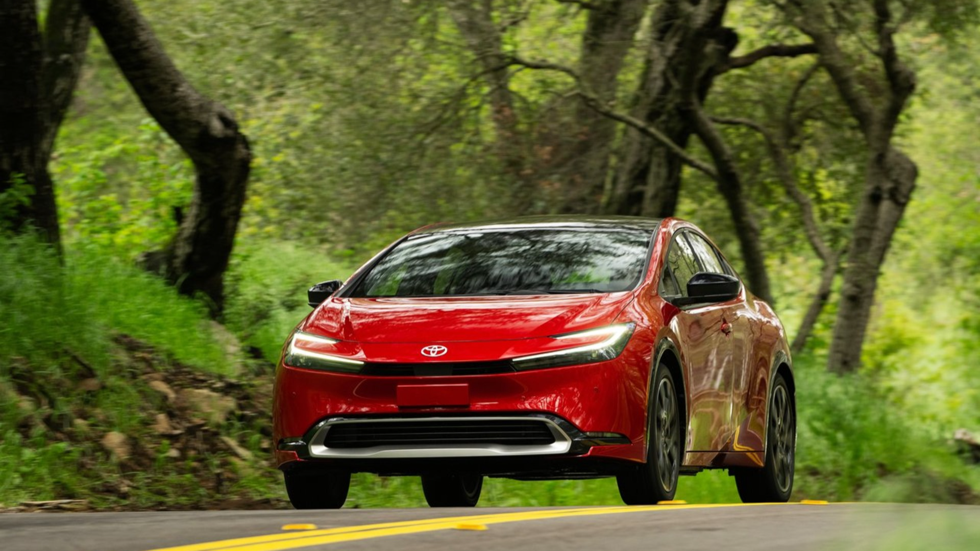 Вождение красного седана Toyota Prius Prime 2023