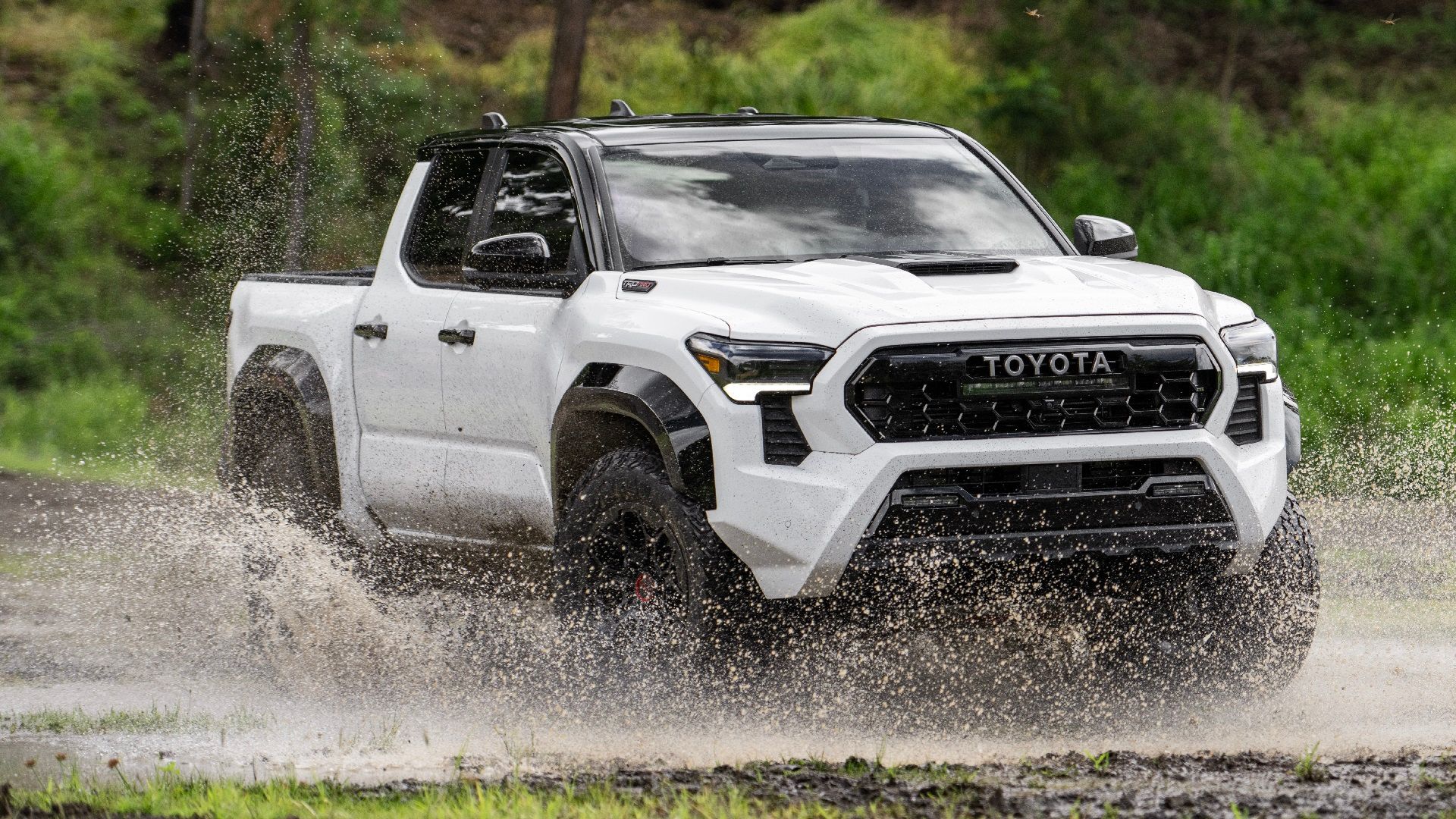 2024 Toyota Tacoma TRD Pro, front-quarter, off-roading over a water puddle.