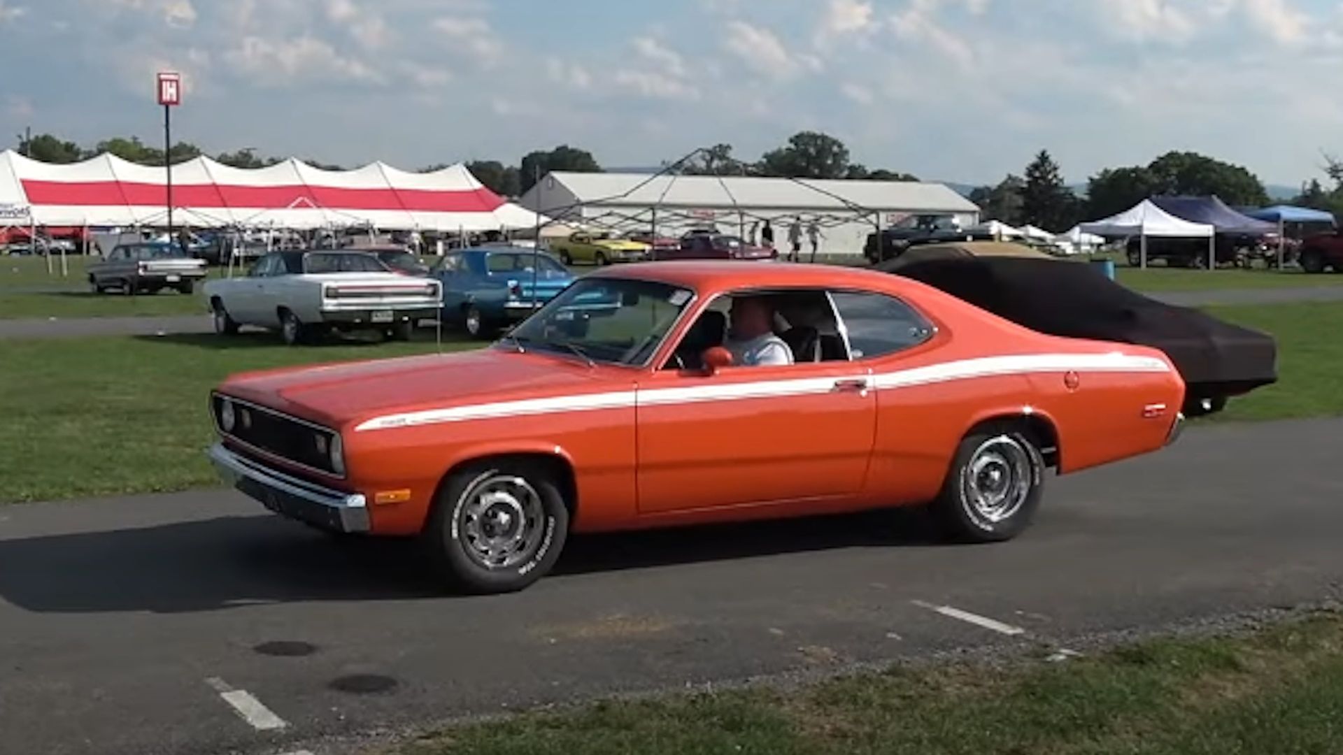 A red 1972 Plymouth Duster being driven