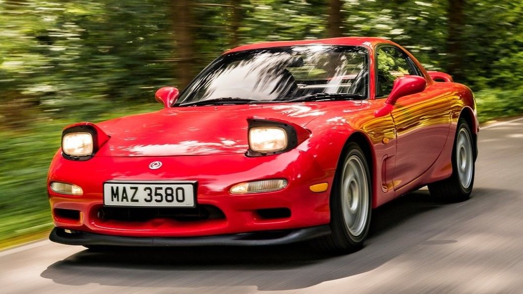 A red 1992 Mazda RX-7 is pulled over on the road