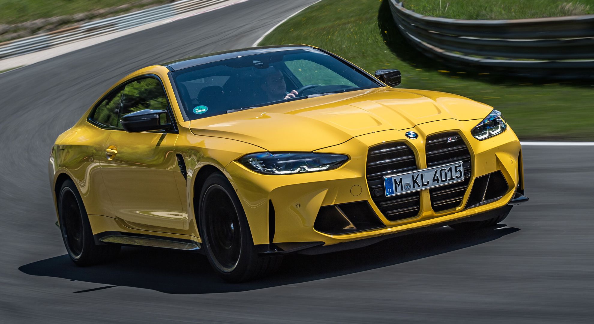 Yellow 2024 BMW M4 Coupe driven on the track