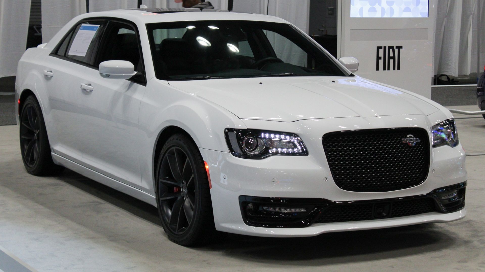 White 2023 Chrysler 300c parked in a vehicle showroom 