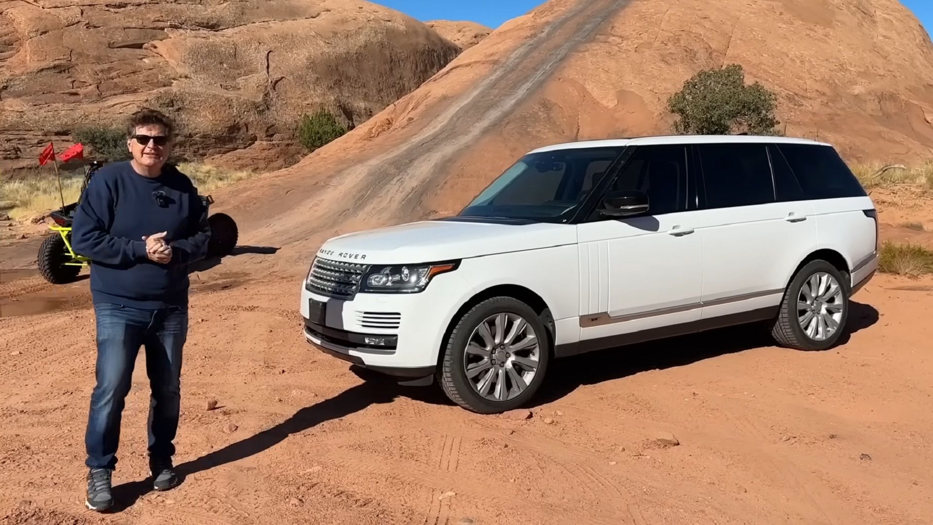 White Range Rover parked on dirt trail 