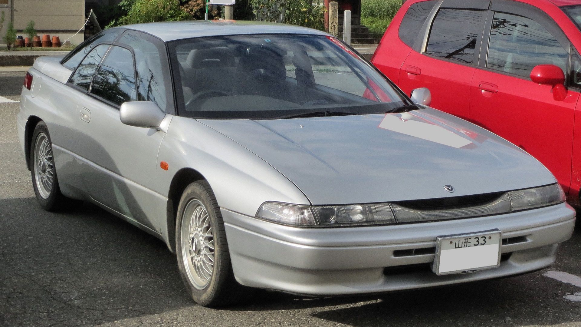 Silver Subaru SVX in parking lot from the front
