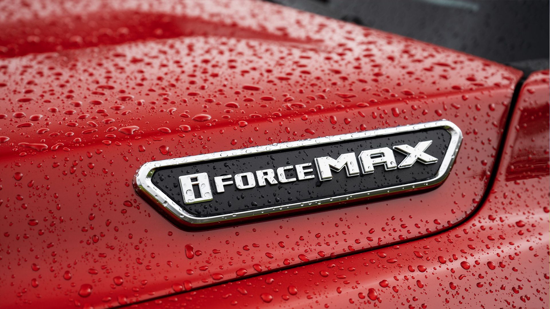 Black and white i-Force MAX badge on a red 2024 Toyota Tacoma Limited