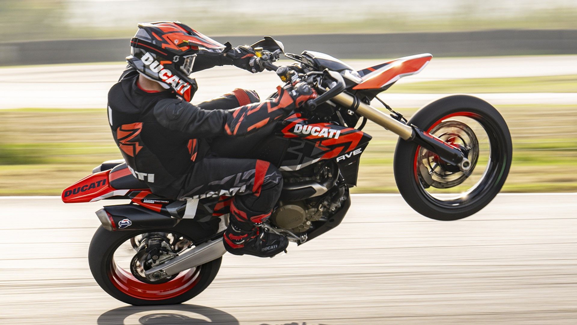 Ducati Hypermotard 698 Mono popping a wheelie side profile view