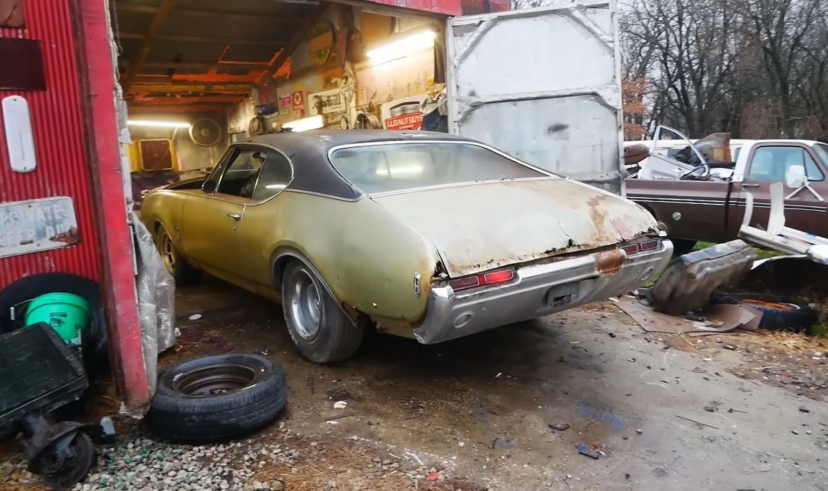 Brown 1968 Oldsmobile Cutlass backing out 