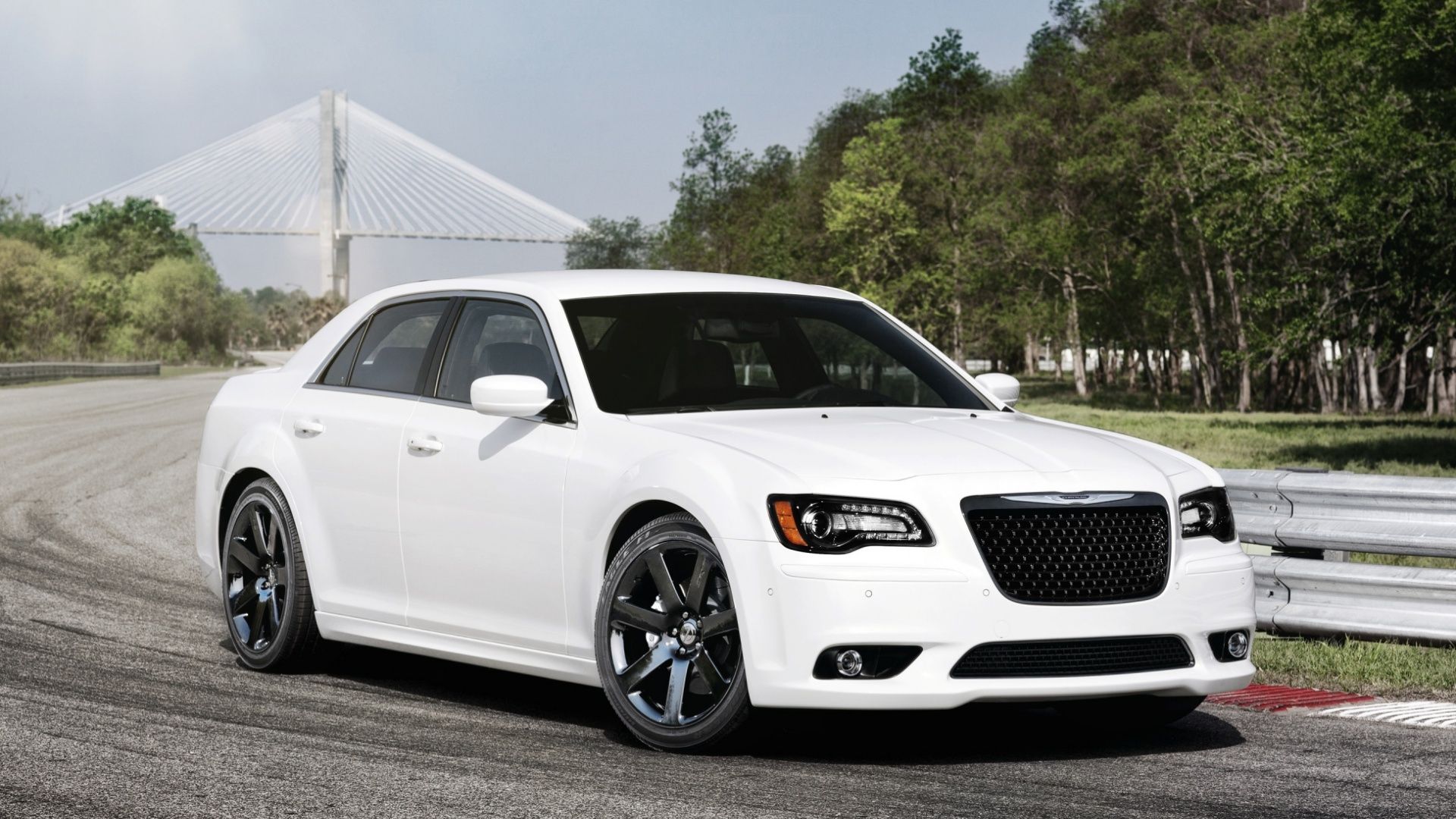 Branco 2012 Chrysler 300 SRT-8 em branco em uma pista de corrida perto de um guard rail.