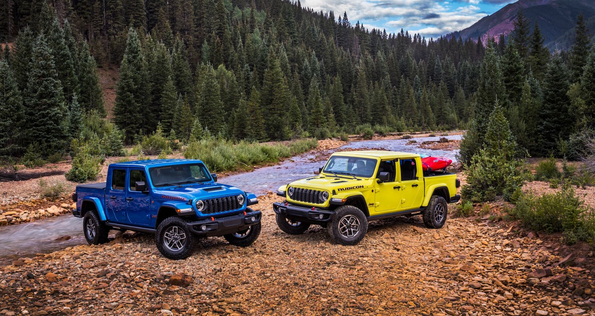 A blue Jeep Gladiator Mojave and a yellow Jeep Gladiator Rubicon next to a stream