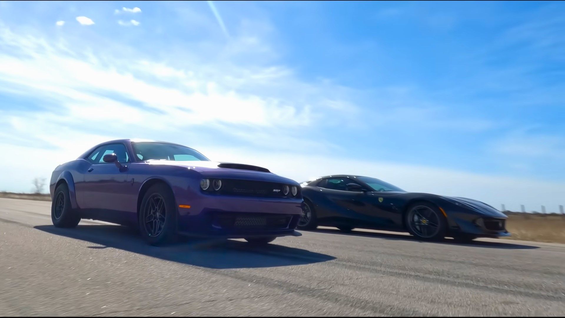 A purple 2023 Dodge Challenger SRT Demon 170 vs a black 2023 Ferrari 812 GTS drag race front quarter shot