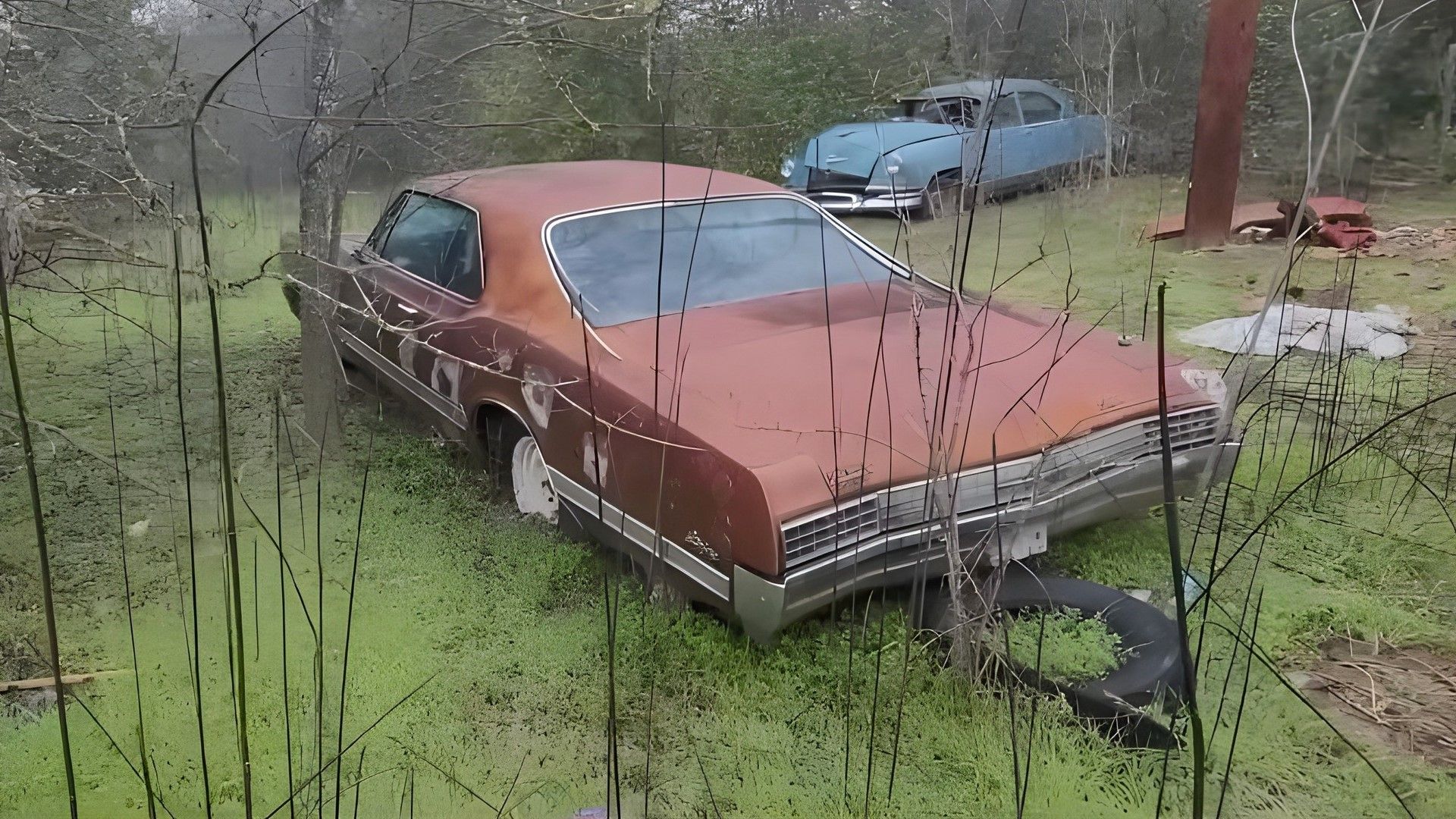 A red 1966 Oldsmobile Starfire junkyard find rear quarter shot