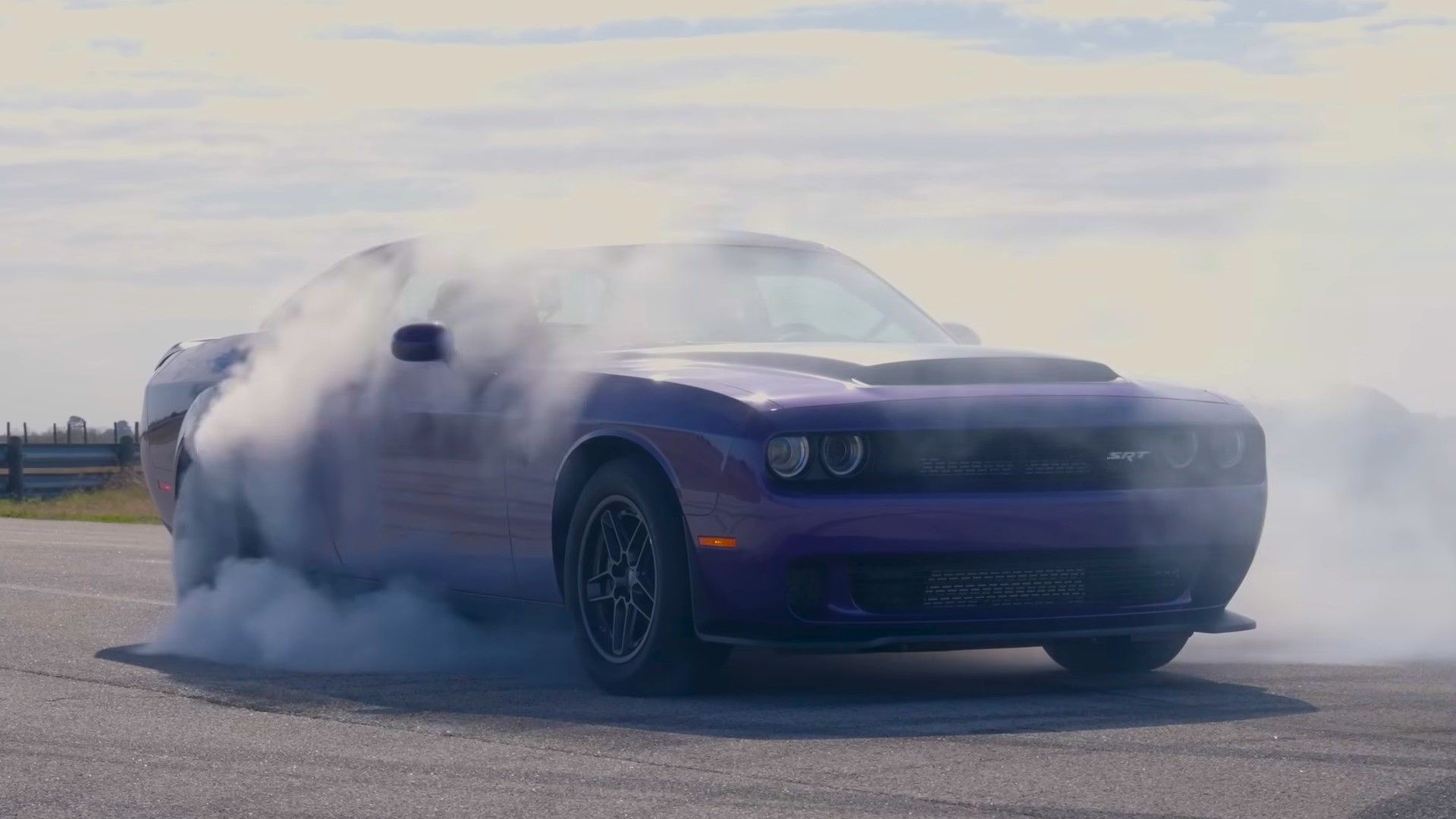 A purple Dodge Challenger SRT Demon 170 doing a burnout front quarter shot