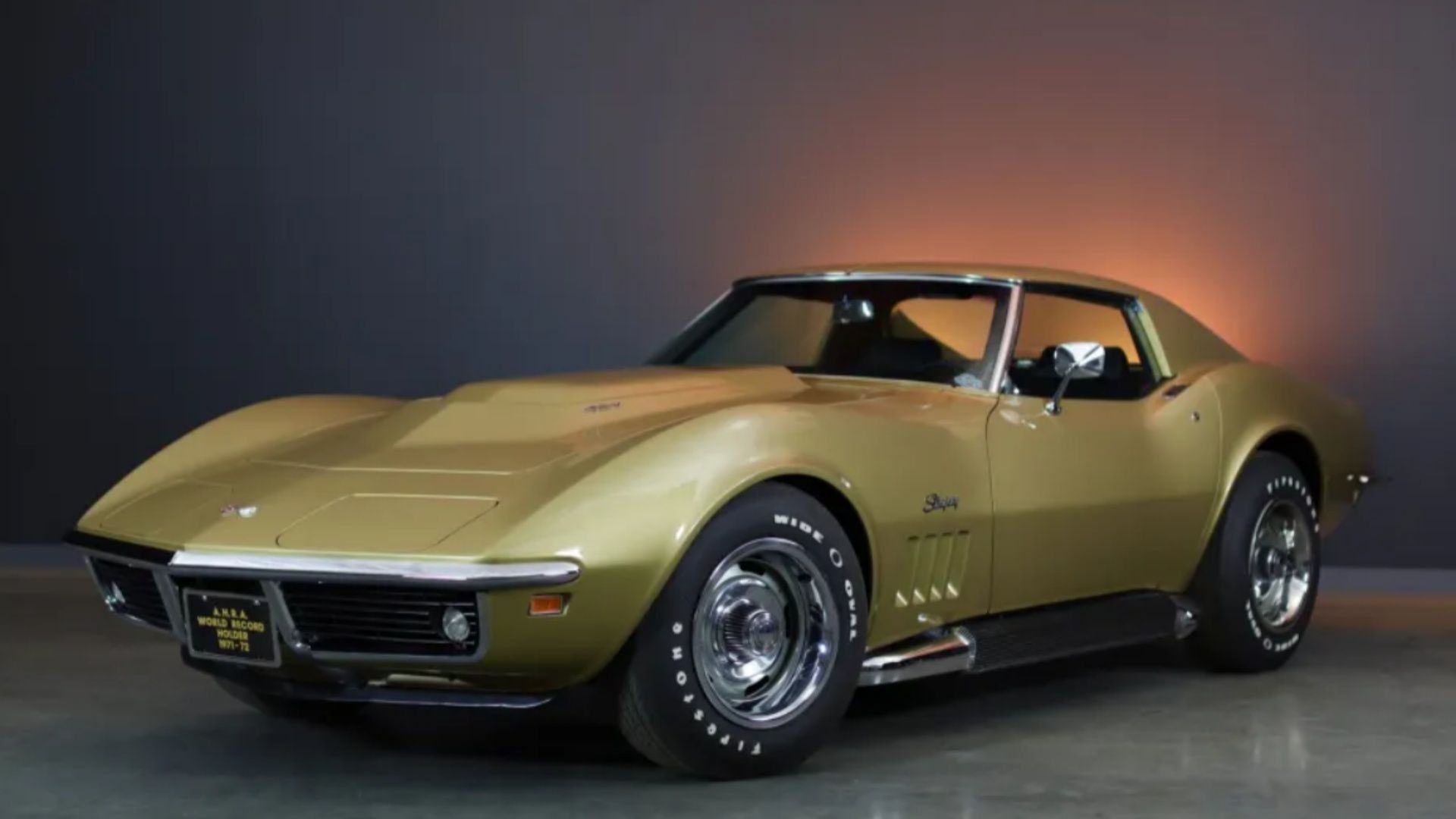 Chevrolet Corvette Coupe L88 4 velocidades 1969 em ouro com fundo preto e laranja.
