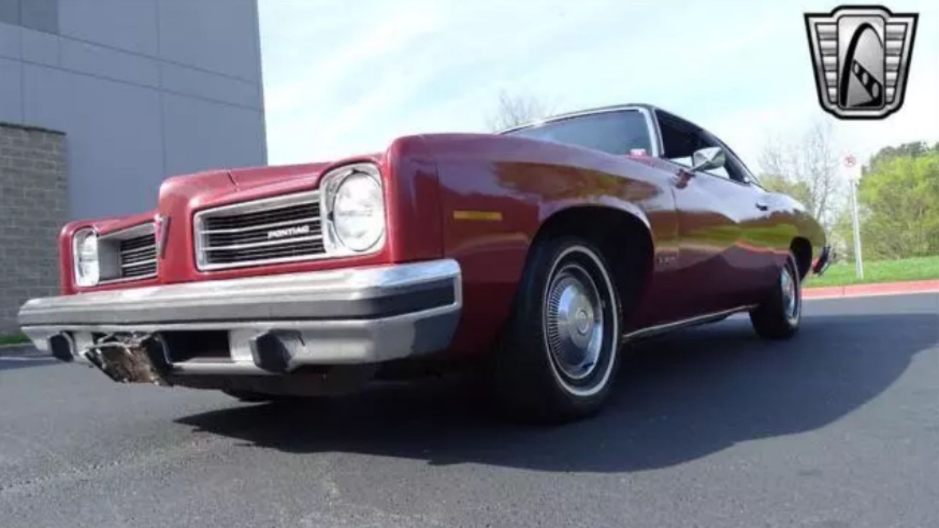 Pontiac LeMans 1974 em vermelho em um estacionamento.