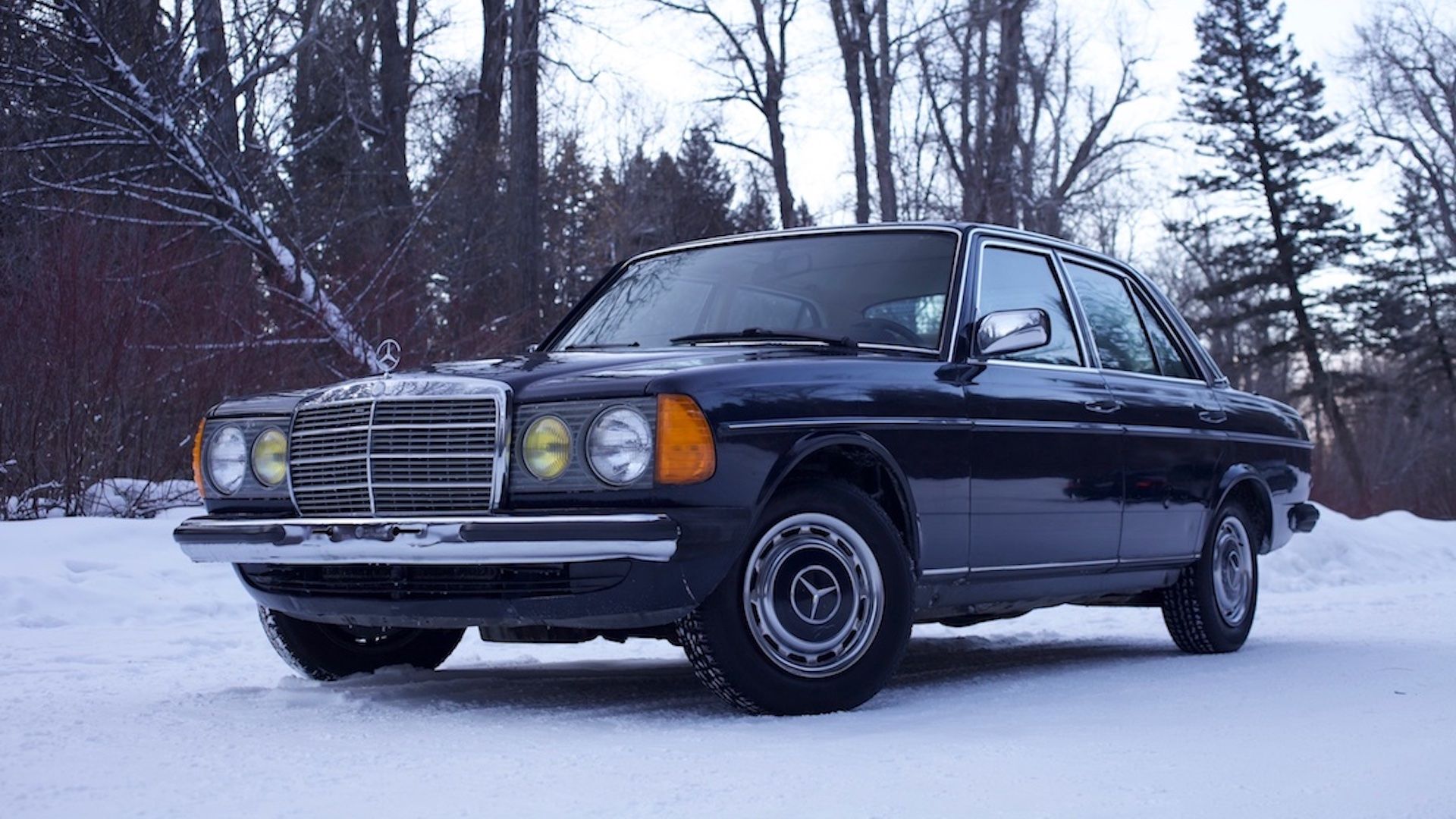 A 1983 Mercedes-Benz 230E parked in the snow