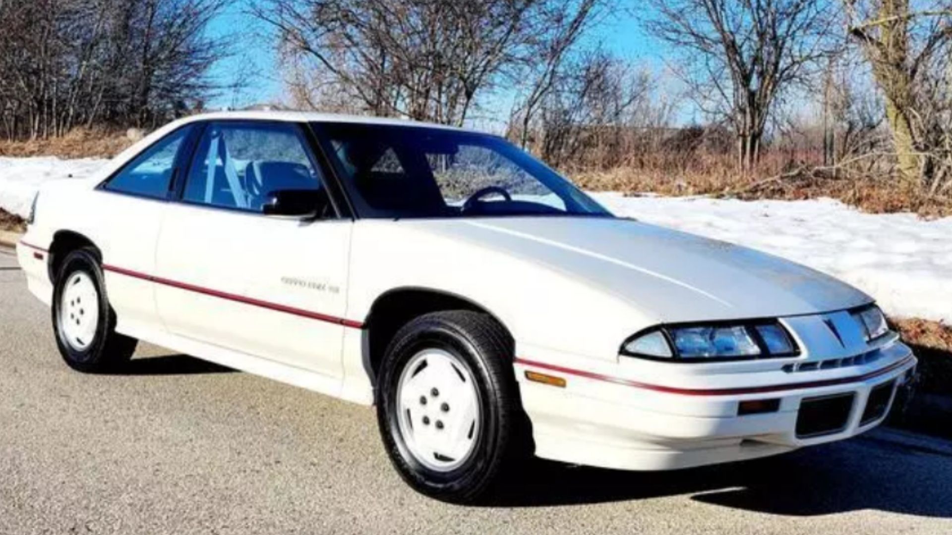 Pontiac Grand Prix SE 1988 em branco com rodas brancas em volta da neve.