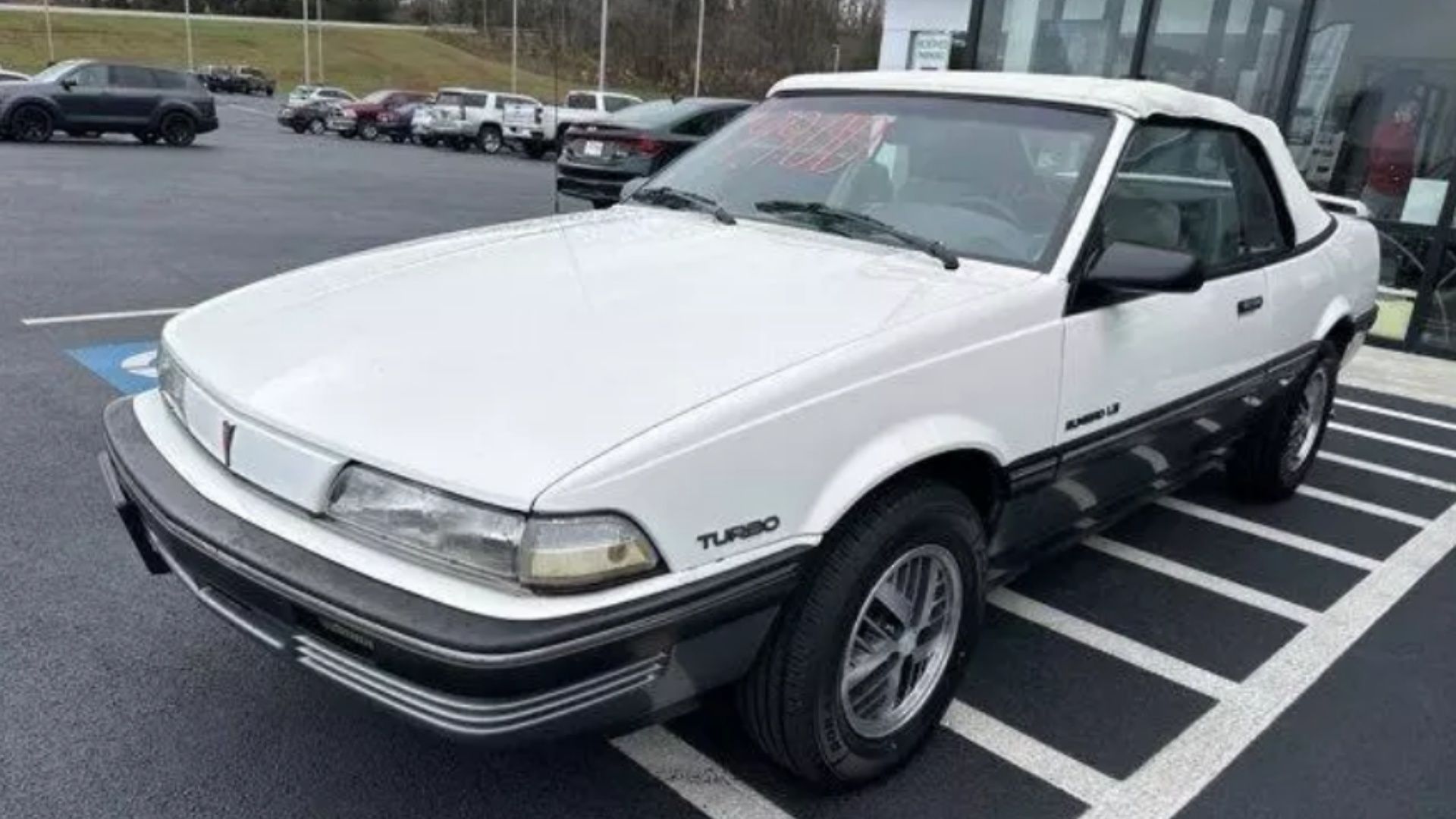 1990 Pontiac Sunbird LE em branco em uma concessionária de automóveis.