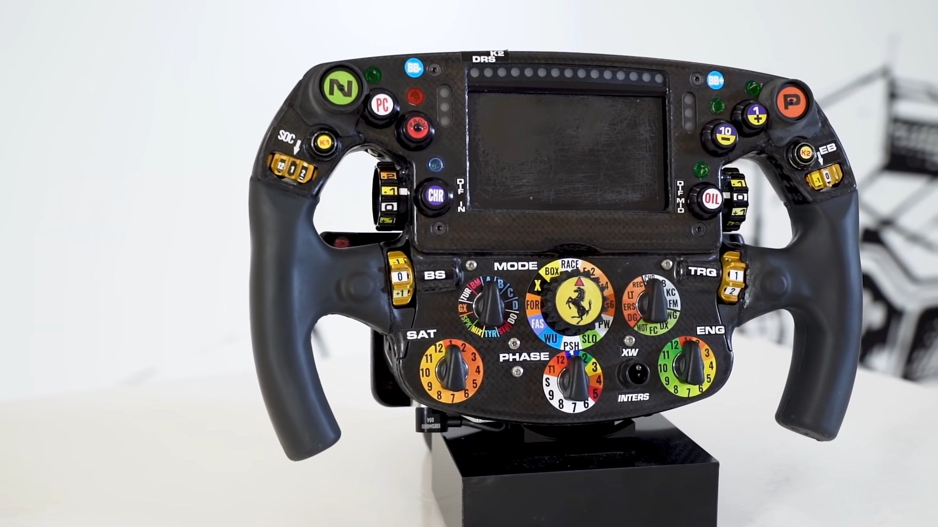 A black carbon Ferrari SF-75 Formula 1 steering wheel front shot