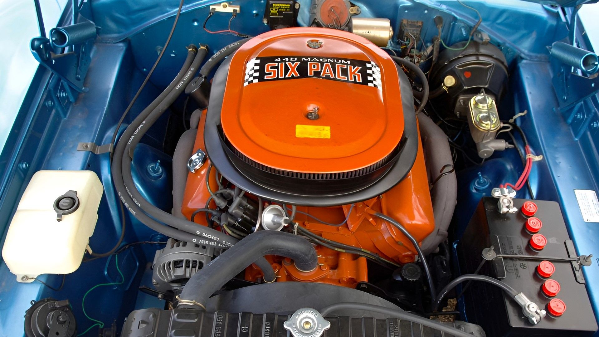 An orange 1970 Dodge 440 Six Pack V8 engine front shot