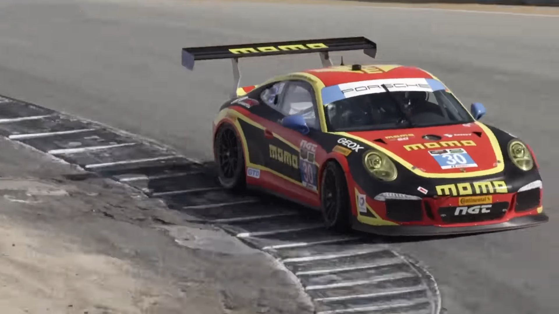 Um Porsche 911 GT3 Cup Car 997 vermelho, preto e amarelo em Laguna Seca, foto frontal