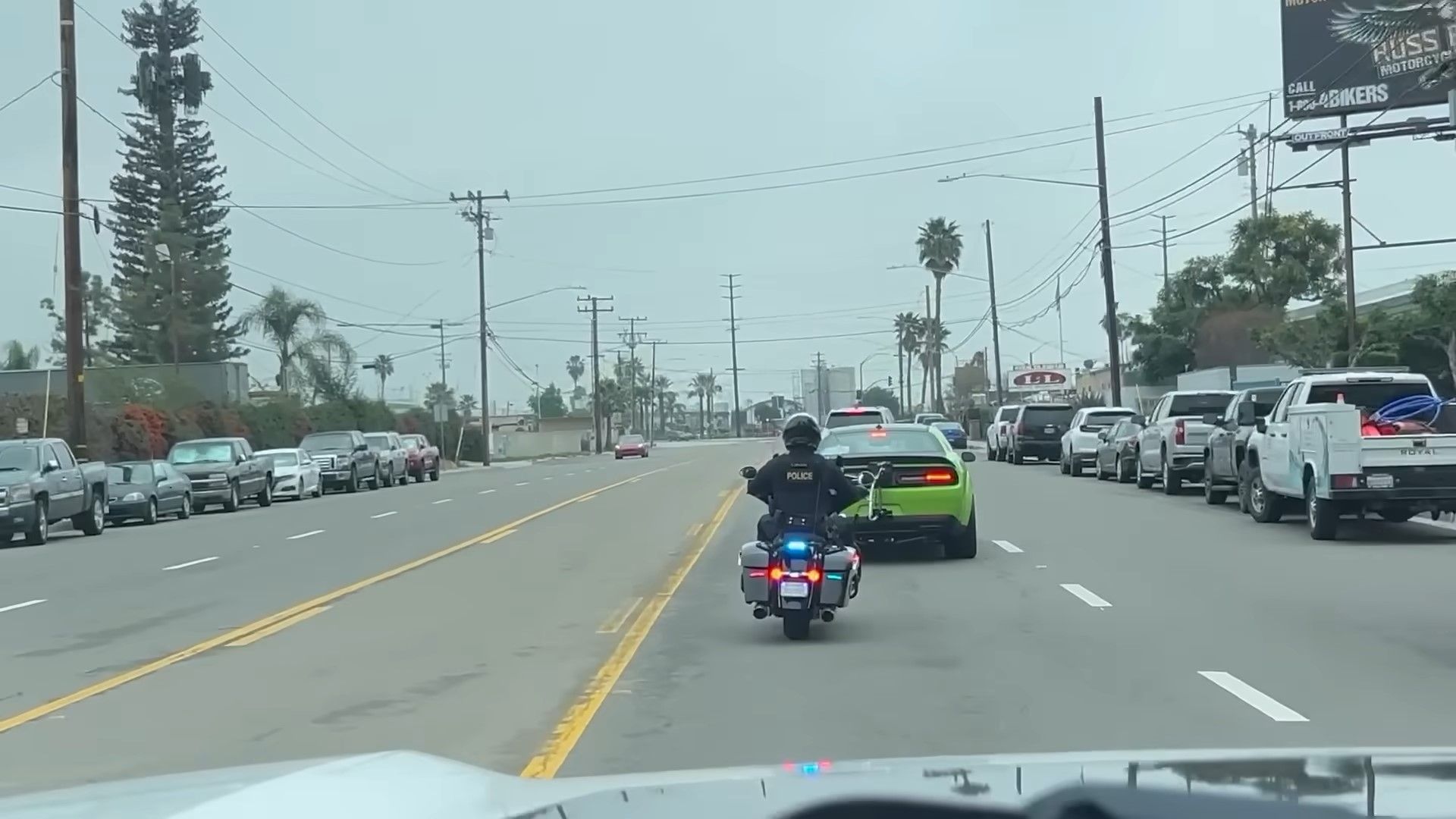 Um sublime Dodge Challenger SRT Demon 170 2023 verde sendo parado por um tiro traseiro da polícia