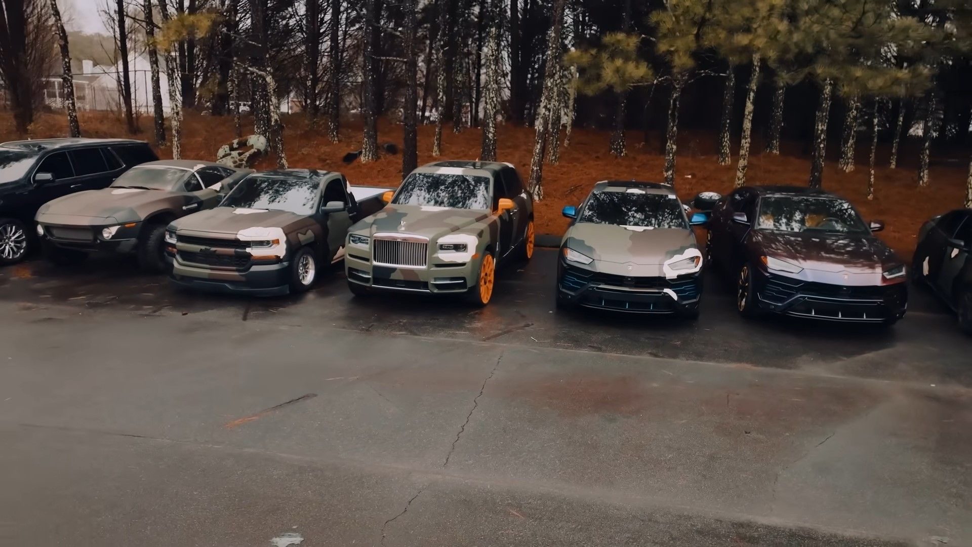 Um Rolls-Royce Cullinan 2021 camuflado e laranja em uma foto frontal de uma frota de automóveis
