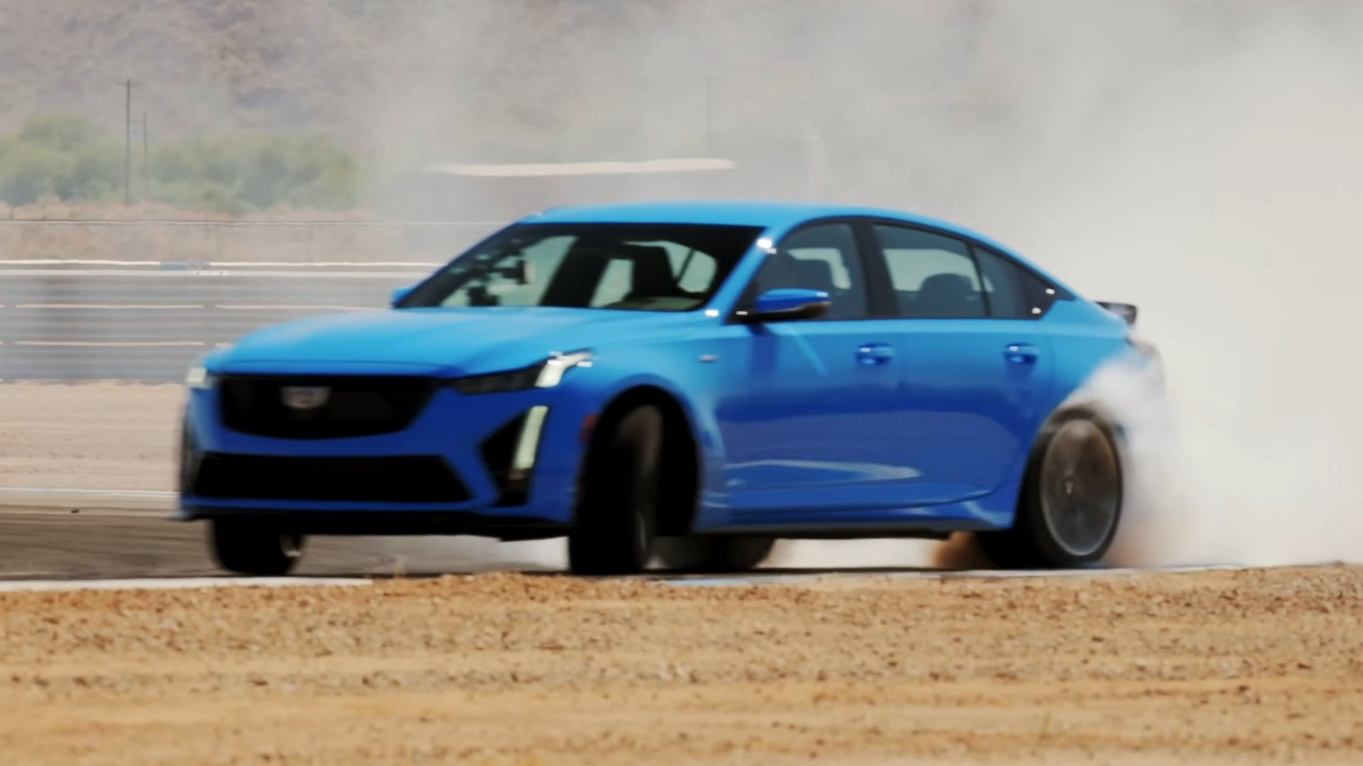 Um Cadillac CT5-V Blackwing 2024 azul à deriva na foto do quarto dianteiro