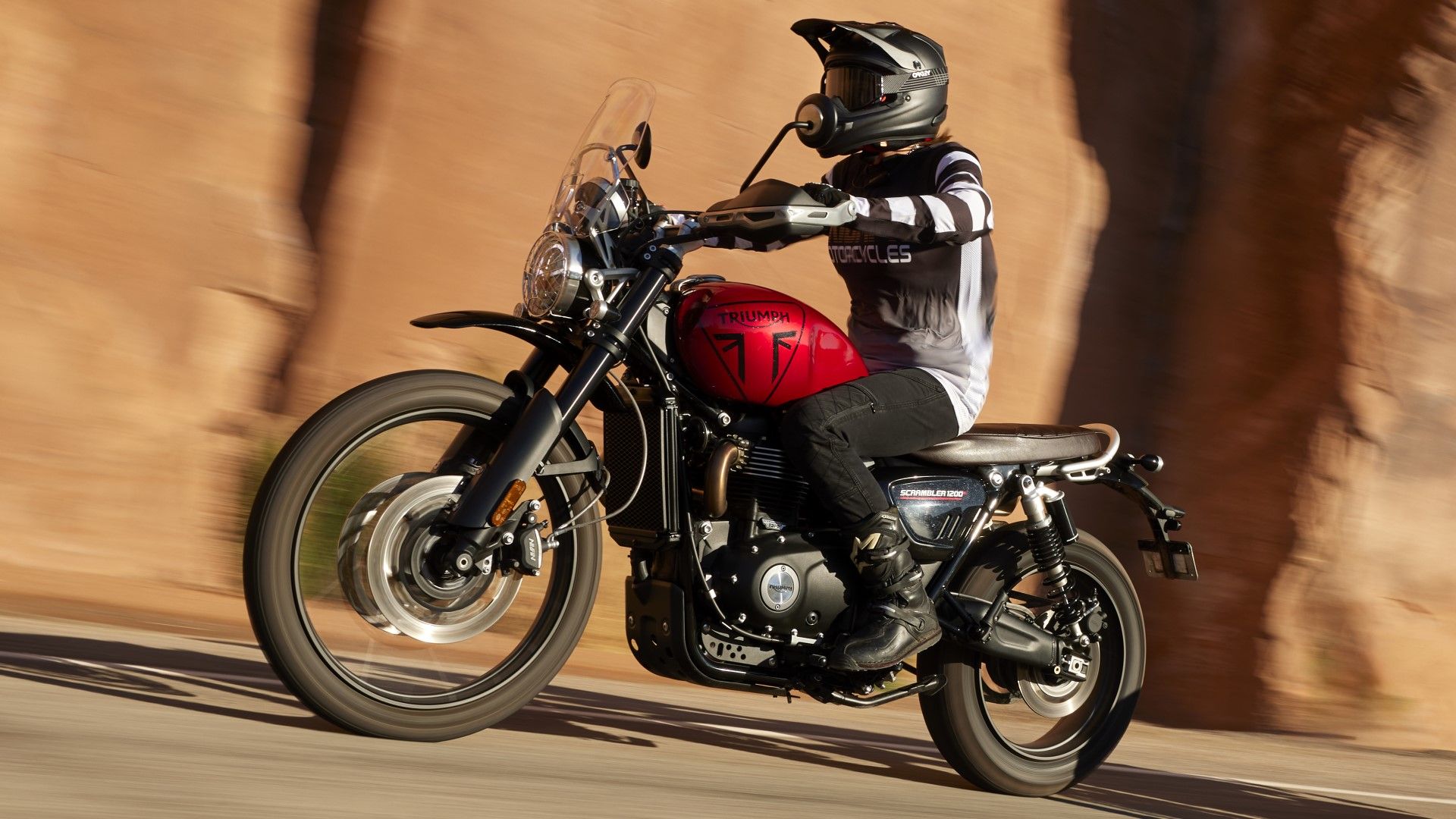 2024 Triumph Scrambler 1200 on the road accelerating side profile view