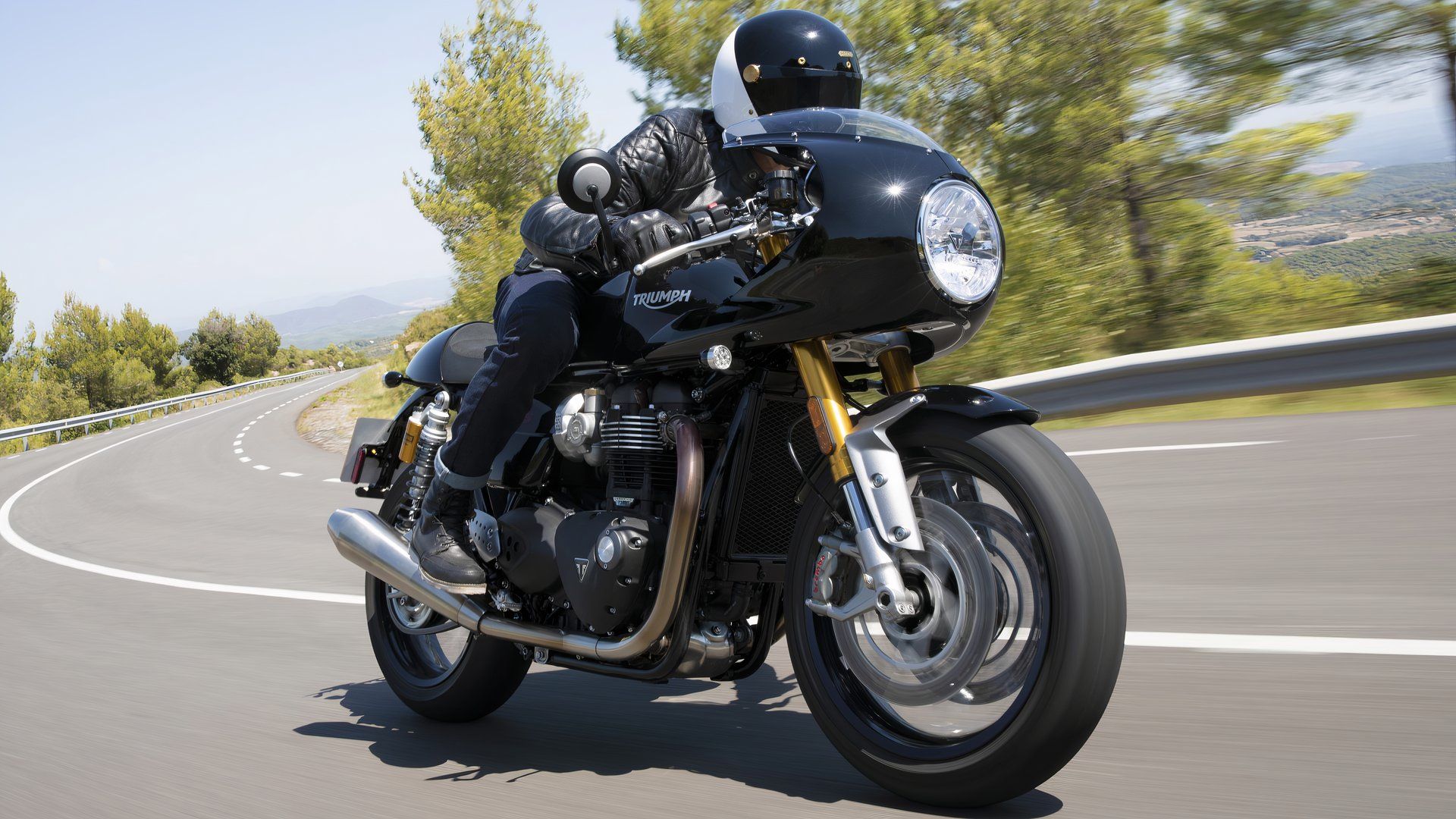 2024 Triumph Thruxton RS with accessory semi-fairing accelerating front third quarter view